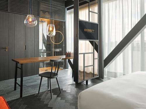 a hotel room with a desk and a bed at east Hotel Hamburg in Hamburg