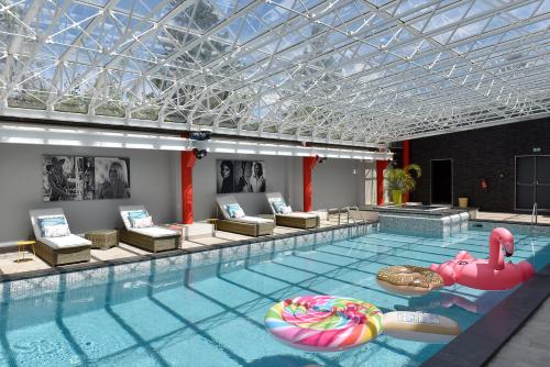 a large swimming pool with an inflatablelatable at Hôtel Arles Plaza in Arles