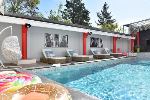 a swimming pool with lounge chairs and a swimming pool at Hôtel Arles Plaza in Arles