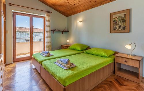 - une chambre avec un lit vert et une grande fenêtre dans l'établissement Apartment Lorencin Milka, à Medulin