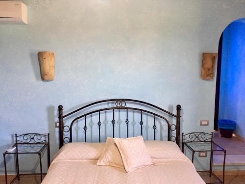 a bedroom with a bed with two night stands at I Carrubi in San Priamo