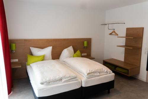 una camera da letto con letto e cuscini gialli di Pension Haas-Hotel am Turm a Rottweil