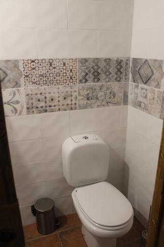 a white toilet in a bathroom with tiles on the wall at Agriturismo La Caraffara sull' Etna in Puntalazzo