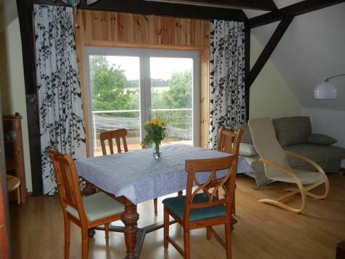 a dining room with a table and chairs and a window at Kranichruf in Schöneberg