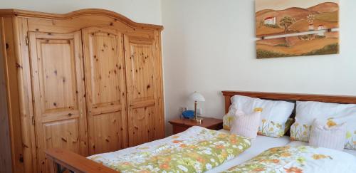 a bedroom with a bed and a wooden cabinet at Gästehaus Casa Cristina in Bad Krozingen