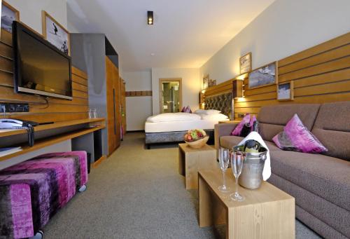 ein Hotelzimmer mit einem Sofa und einem Bett in der Unterkunft Hotel Vista Allegra in Ischgl