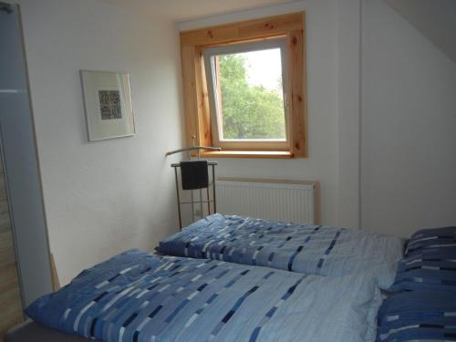 a bedroom with a bed and a window at Kranichruf in Schöneberg