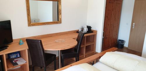 a room with a table with two chairs and a mirror at Gästehaus Casa Cristina in Bad Krozingen