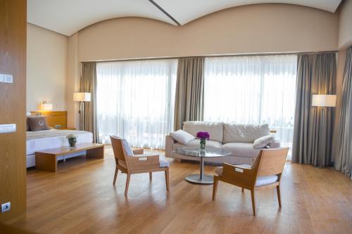 a living room with a couch and a table and chairs at ON'LIVE HOTEL in Cesme