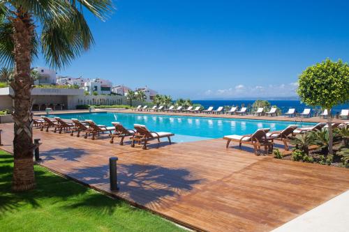 a swimming pool with chaise lounges and chairs in a resort at ON'LIVE HOTEL in Cesme
