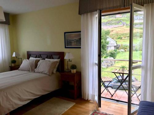 a bedroom with a bed and a door to a balcony at Casa Pío Nigrán, vistas Islas Cíes in Nigrán