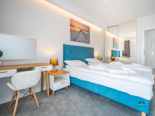 a bedroom with a bed and a desk and a computer at 3L Apartments Aquarius in Kołobrzeg