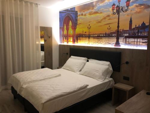 um quarto com uma cama com um quadro na parede em Hotel Altinate em Lido di Jesolo