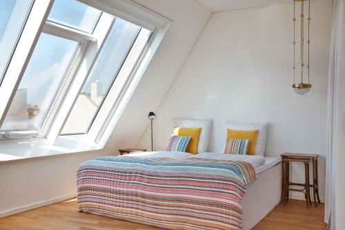 a bed in a room with large windows at Joachim 8 Maisonette Apartment in Berlin