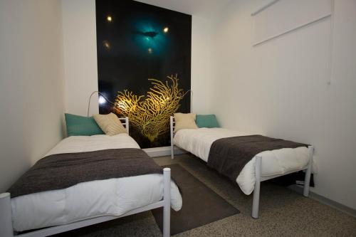 two beds in a room with a painting on the wall at Turismo do Seculo in Estoril