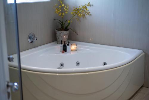 a bathroom with a tub with a plant in it at Luxury Beach Apartments in Amanzimtoti