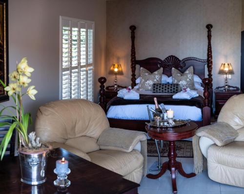 1 dormitorio con 1 cama, 2 sillas y mesa en Luxury Beach Apartments, en Amanzimtoti