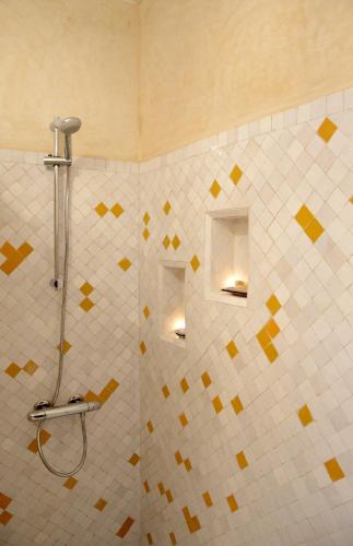 a bathroom with a shower with yellow and white tiles at RIAD OASIS D'ASILAH in Asilah