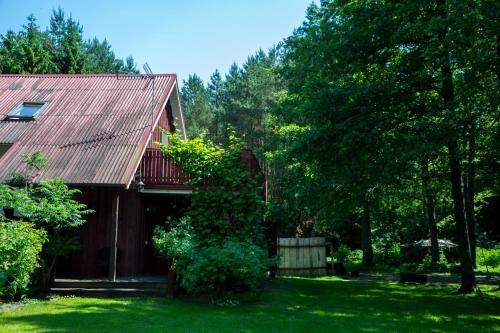 a house with a red roof and some trees at Adeles sodyba in Sturmai