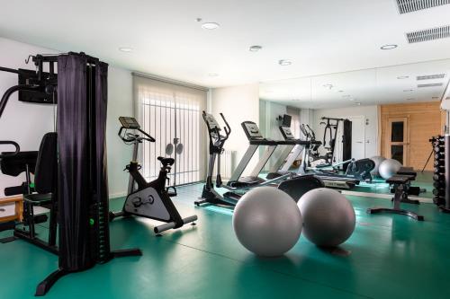 a gym with several treadmills and exercise bikes at Parador de Cuenca in Cuenca