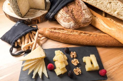 a table with different types of bread and cheese at Parador de Cuenca in Cuenca