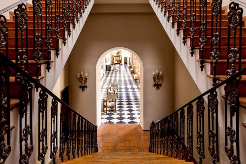 a hallway with a checkerboard floor in a house at Parador de Cuenca in Cuenca