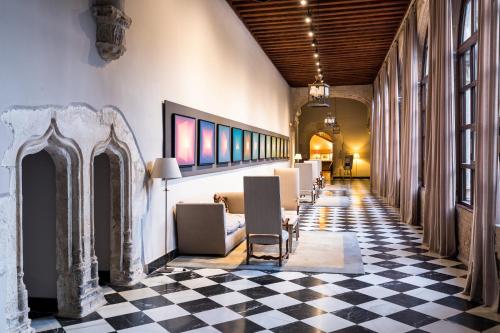 a room with a checkered floor and a hallway at Parador de Cuenca in Cuenca
