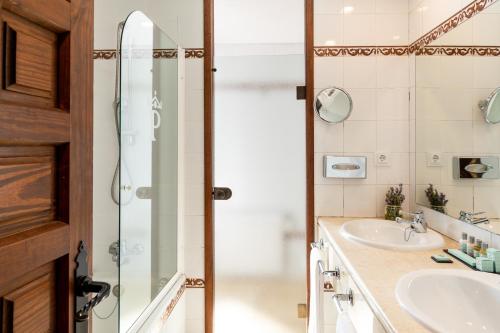 a bathroom with two sinks and a shower at Parador de Cuenca in Cuenca