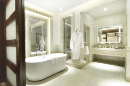 a bathroom with a large tub and a sink at Goot Resorts in Riyadh