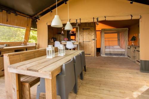 a kitchen with a large wooden table and chairs at Lodge Holidays - Glamping San Marino in San Marino