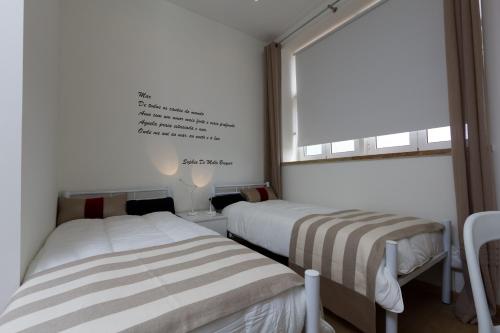 two beds in a room with a window at Turismo do Seculo in Estoril