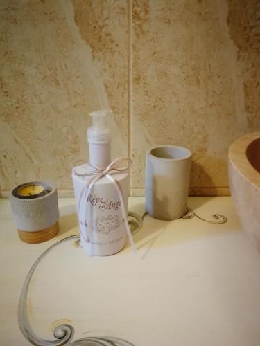 a bathroom counter with a bottle of soap and candles at Sia & Sophie House Oradea in Sîntandrei