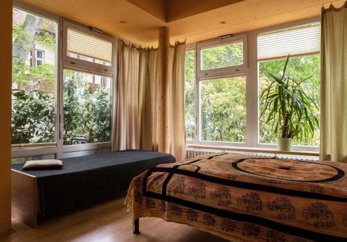 a bedroom with a bed and large windows at Wohnen im Zentrum in Potsdam