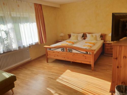 a bedroom with a bed and a television in it at Gästehaus Casa Cristina in Bad Krozingen