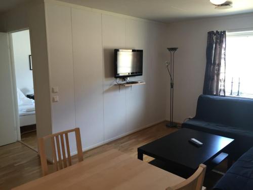sala de estar con sofá, mesa y TV en Beiarn kro og Hotell en Storjorda