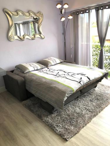 - un lit dans une chambre avec un miroir mural dans l'établissement Studio ST-MANDRIER 300m MER, à Saint-Mandrier-sur-Mer
