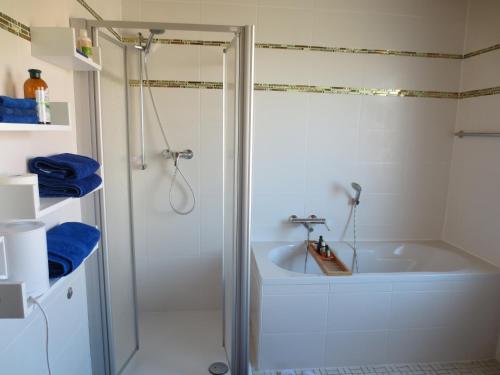 a bathroom with a shower and a white tub at Gesund-Wellness in Mandern