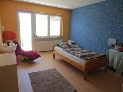 a bedroom with a bed and a blue wall at Gesund-Wellness in Mandern