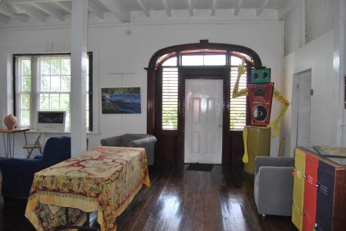 een kamer met een tafel en een deur en een kamer met stoelen bij Mobay Kotch in Montego Bay