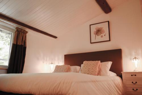 a bedroom with a bed with white sheets and a window at Chambres d'Hôtes Domaine du Hameau Baylesse in Saint-Jean-dʼAigues-Vives