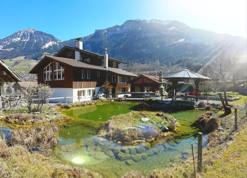 a house with a pond in the middle of a yard at Ferienhaus Lungern see-you in Lungern