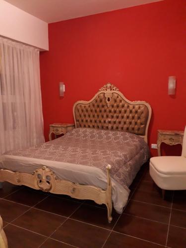 a bedroom with a bed and a red wall at Edificio Valle in Mar del Plata