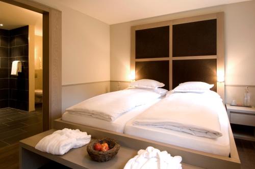 a bedroom with a large bed and a mirror at Hotel und Naturresort Handeck in Guttannen