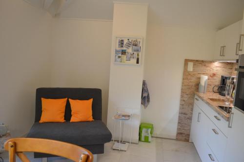 a room with a chair with orange pillows in it at Villa Bellevue in Waldkappel