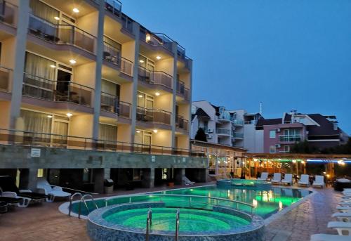 a hotel with a pool in front of a building at Tropics Hotel - Ultra All Inclusive in Sveti Vlas