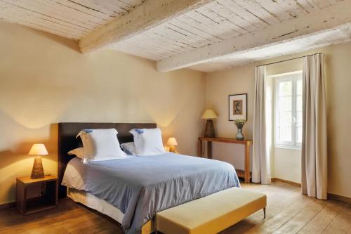 een slaapkamer met een groot bed en een raam bij Maison Hache in Eygalières