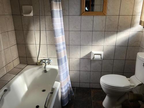 a bathroom with a toilet and a bath tub with a toilet istg at Sonnestrale in Margate