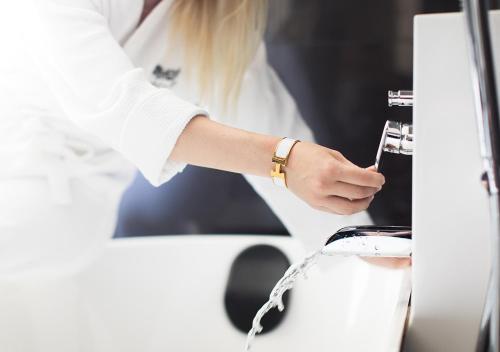 a woman is washing a car with a faucet at Stufvenäs Gästgifveri in Söderåkra