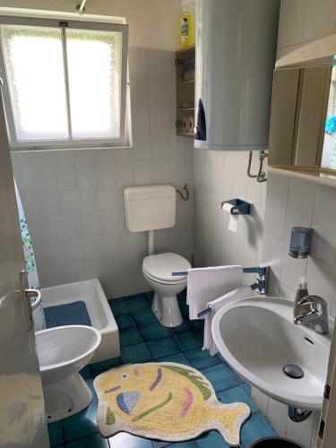 a small bathroom with a sink and a toilet at House Amalia in Bled