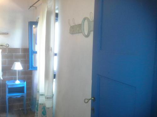 a blue door in a room with a blue chair at B&B Corte San Lussorio in Oliena
